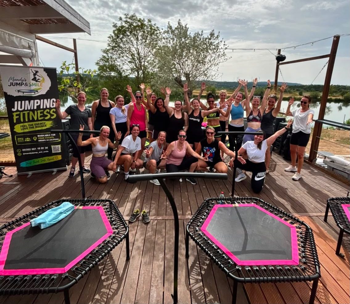 A jumping-fitness class on the lakeside terrace, hands in the air after the session
